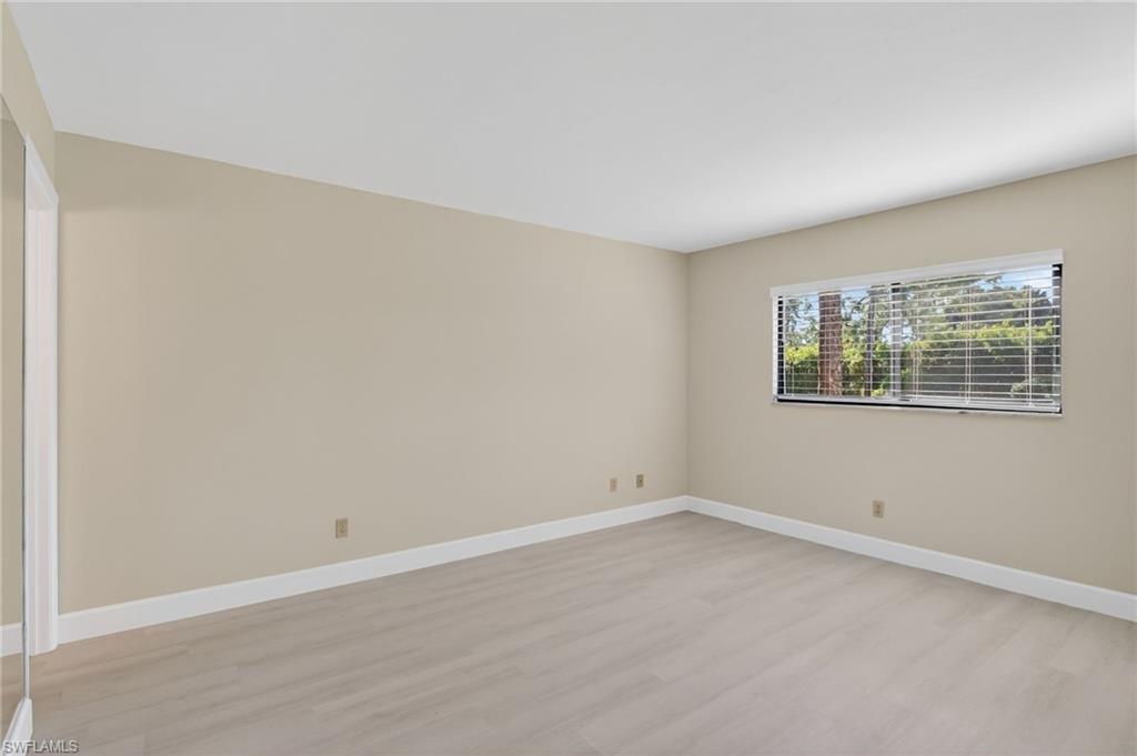 Spare room with light vinyl-style floors and baseboards
