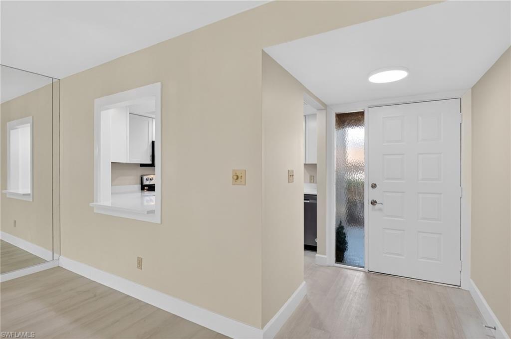 Foyer entrance with light wood-style floors and baseboards