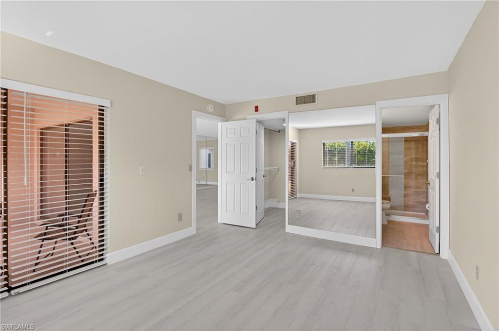 Master bedroom with a closet, light vinyl finished floors, and ensuite bathroom