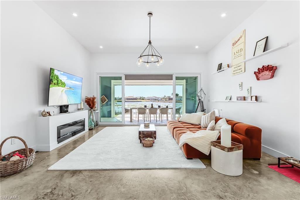 Living room with concrete floors and suspended lighting