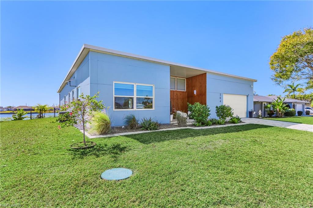 Modern home with a front lawn, driveway, and a garage