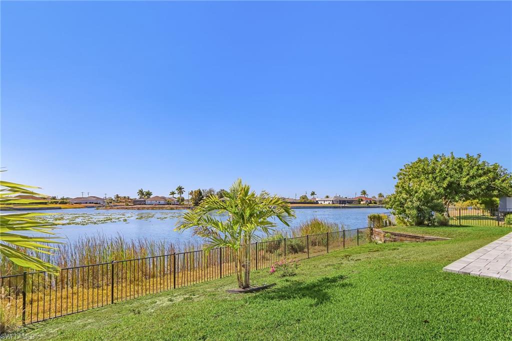 Fenced yard featuring a water view