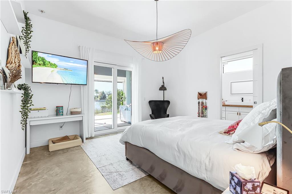 Bedroom featuring concrete flooring, access to outside, and connected bathroom