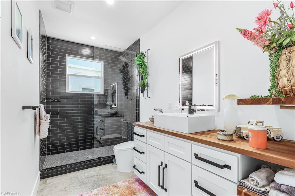 Bathroom featuring vanity, a walk in shower, and recessed lighting