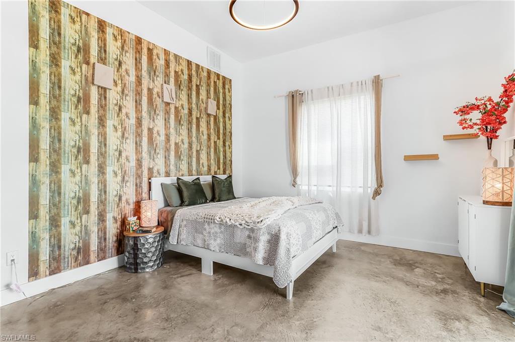 Bedroom featuring finished concrete floors and baseboards