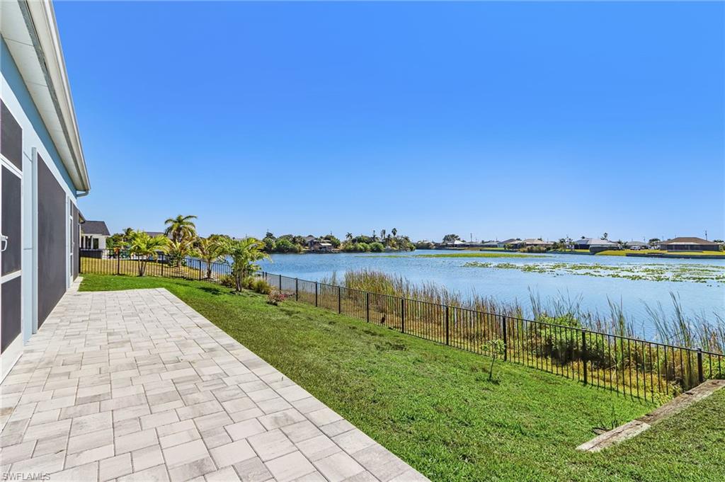 Fenced backyard featuring a water view and a patio