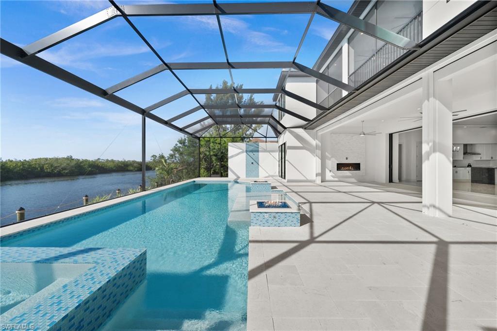 Combined pool / hot tub with a sunroom, a patio area, a lanai, and a storage unit