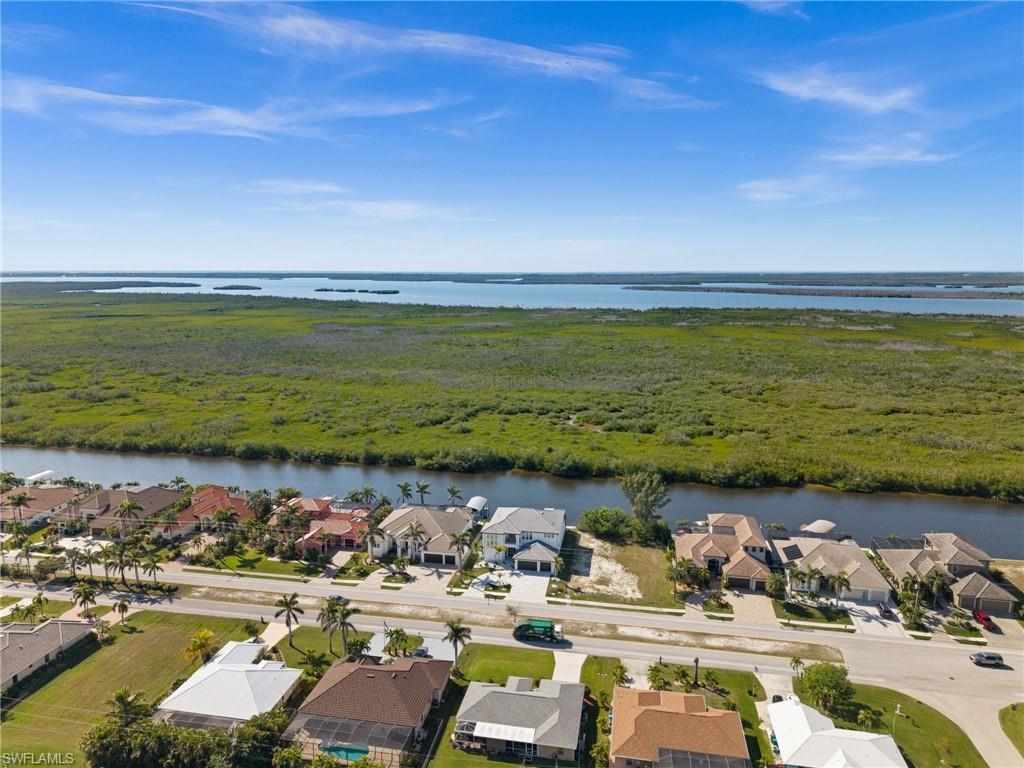 Aerial view of residential area with a large body of water and a heavily wooded area