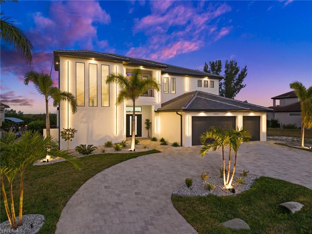 Modern home with a yard, stucco siding, driveway, french doors, and a garage