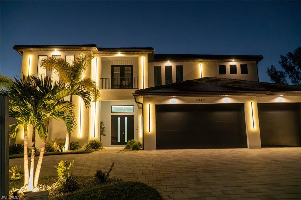View of front of home with a balcony, stucco siding, and driveway