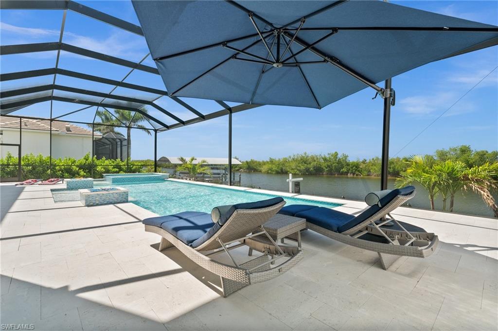 Integrated pool / spa featuring glass enclosure, a patio area, and a sunroom