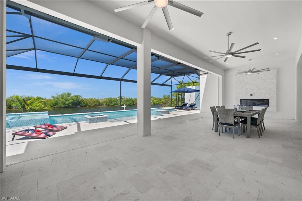 Integrated pool / hot tub featuring a lanai, a patio, outdoor dining area, and a sunroom