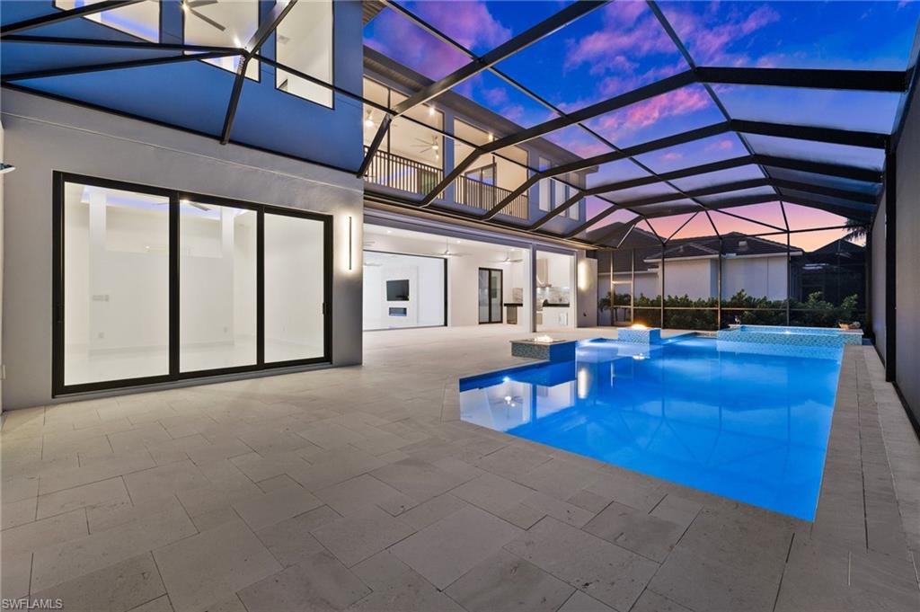 Swimming pool featuring glass enclosure, a sunroom, and a patio area