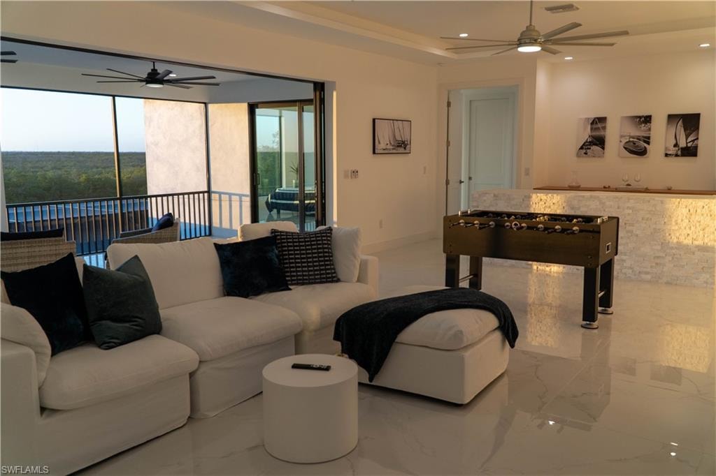 Living area featuring a ceiling fan, recessed lighting, and marble tiled floors