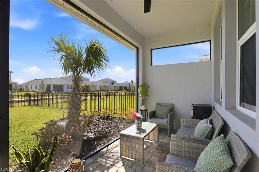 Sunroom / solarium with a ceiling fan, a residential view, outdoor furniture, and a patio area