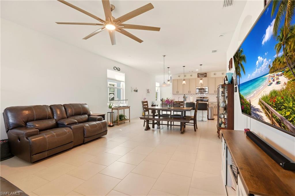 Living room featuring a ceiling fan and light tile patterned floors