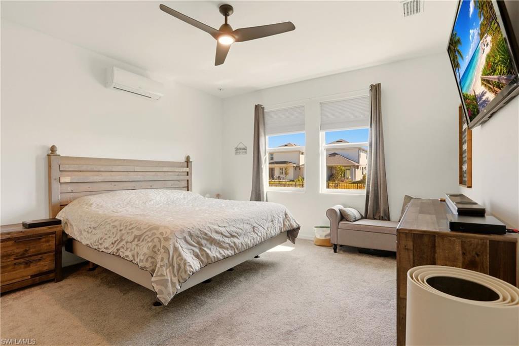 Carpeted bedroom featuring ceiling fan and a mini split for heating / cooling