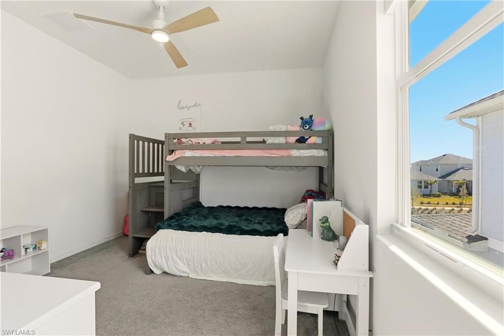 Bedroom with light colored carpet and ceiling fan