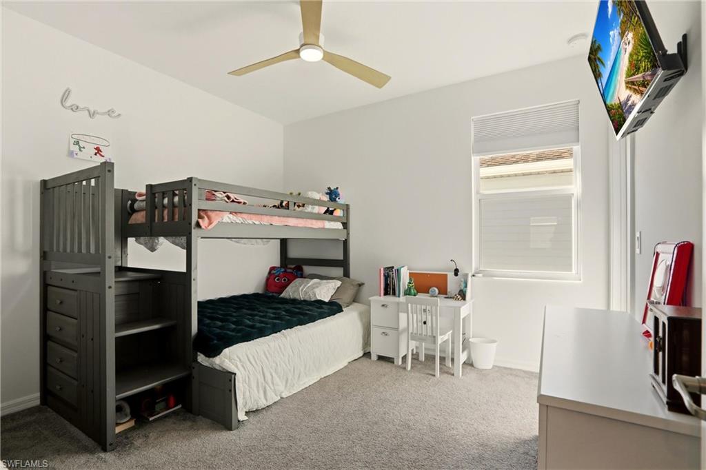 Bedroom with light carpet and a ceiling fan