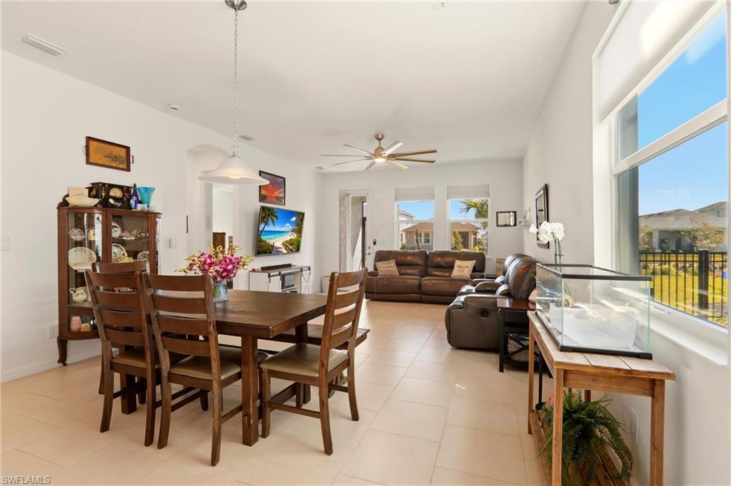 Dining area with ceiling fan, light tile patterned floors, and arched walkways
