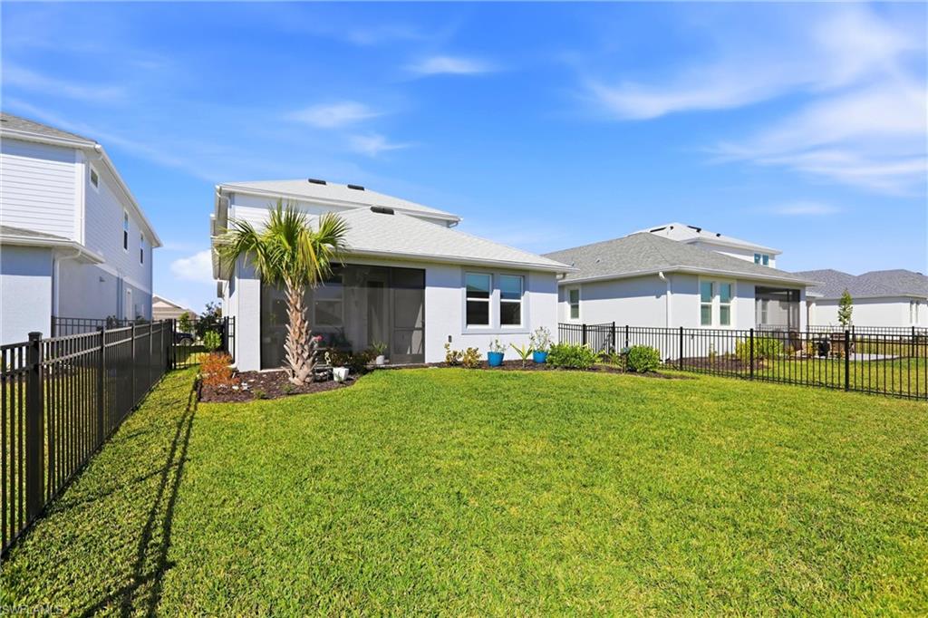 Back of house with a sunroom, a fenced backyard, and stucco siding