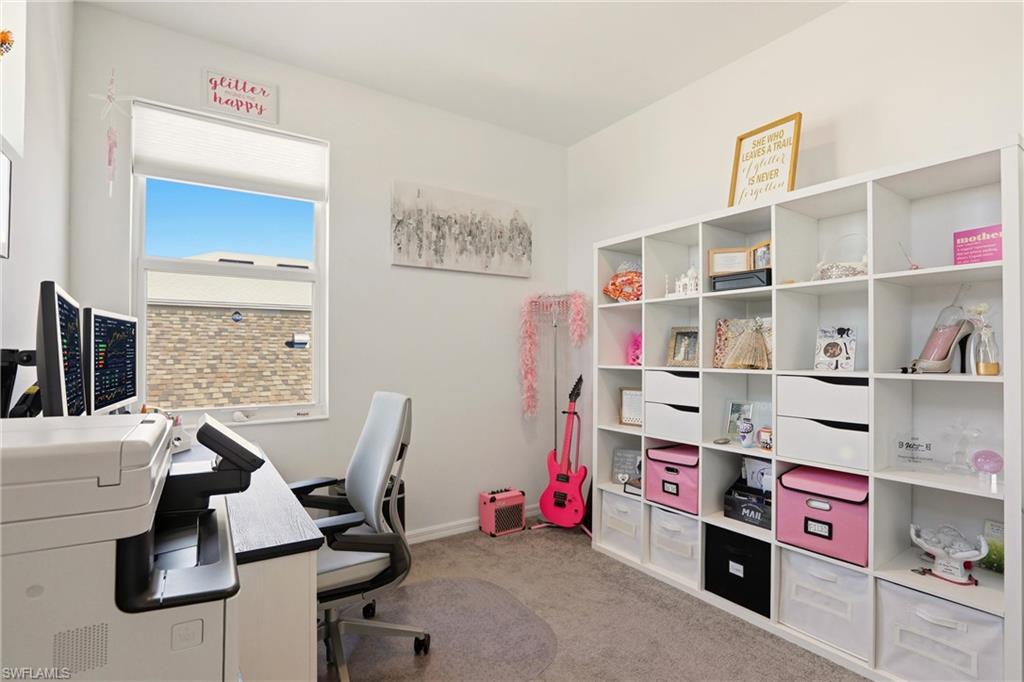 Office space with light colored carpet and baseboards