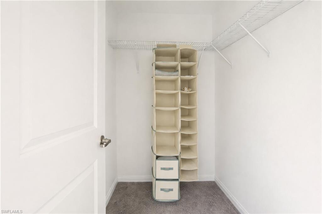 Walk in closet featuring dark colored carpet