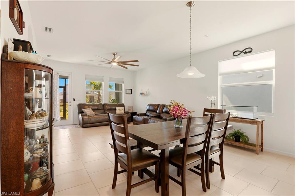 Dining space with light tile patterned flooring and a ceiling fan