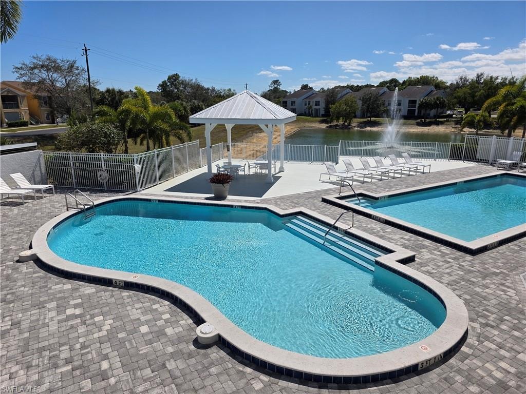 Community pool featuring a gazebo, a patio area, and a water view