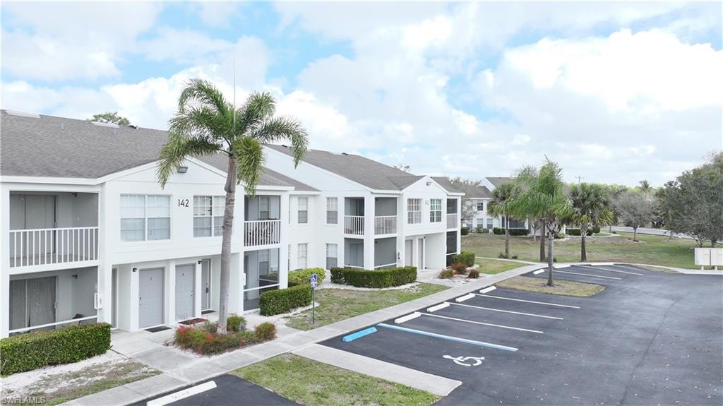 View of property featuring uncovered parking
