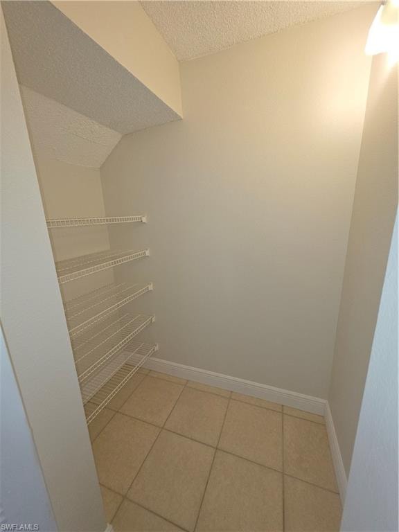 Walk in pantry featuring light tile patterned floors