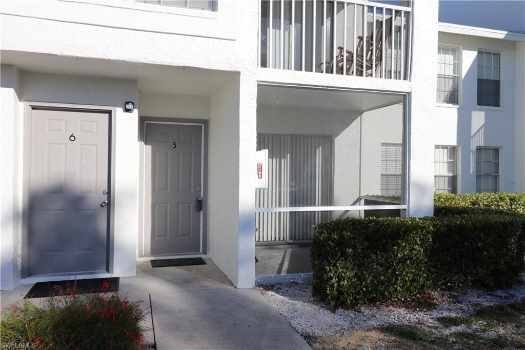 Property entrance with stucco siding and covered porch
