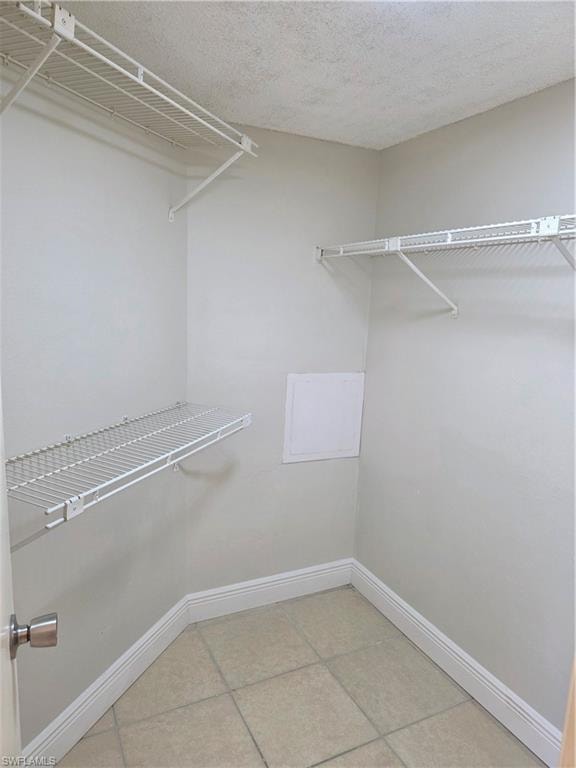 Walk in closet with light tile patterned flooring