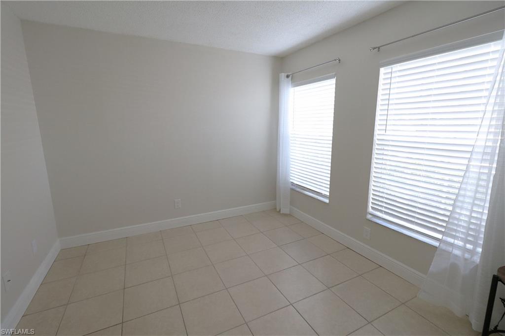 Spare room with light tile patterned flooring and a textured ceiling