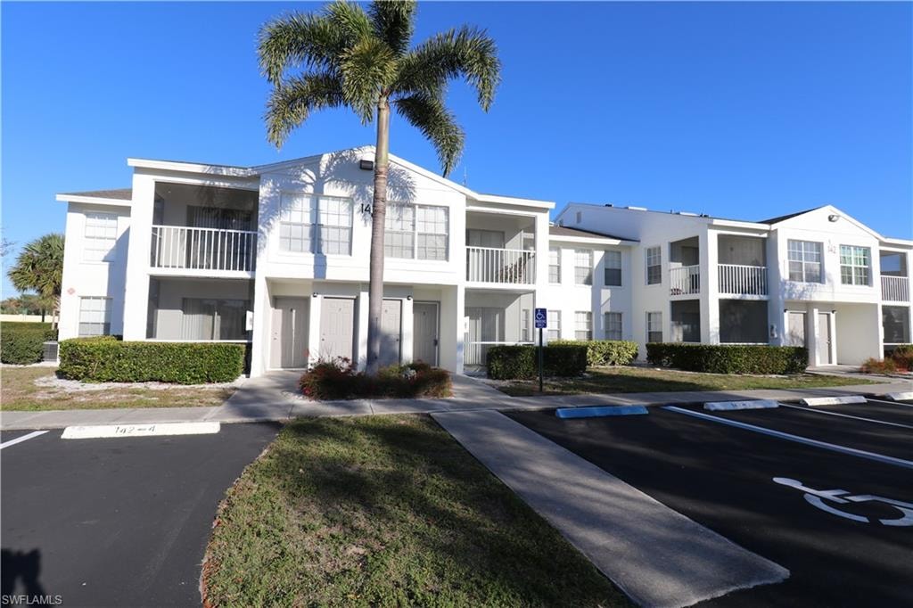 View of apartment building / complex with uncovered parking