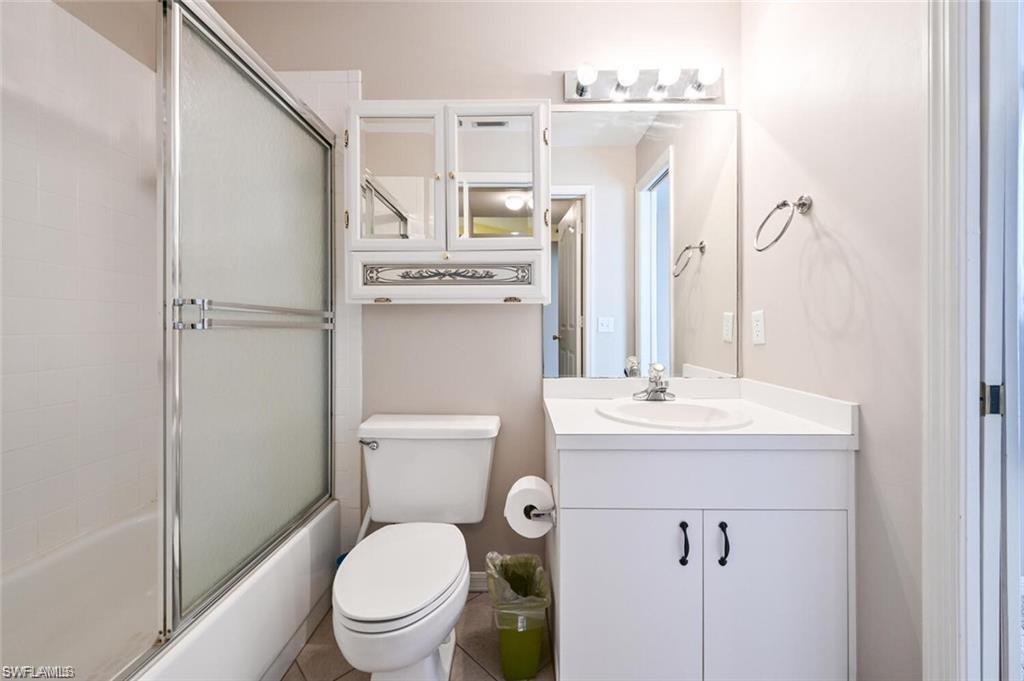 Full bathroom with vanity and enclosed tub / shower combo