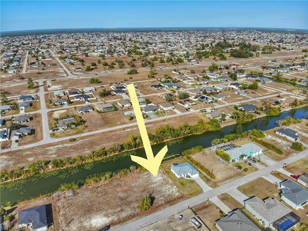 Aerial view of property and surrounding area featuring nearby suburban area and a nearby body of water