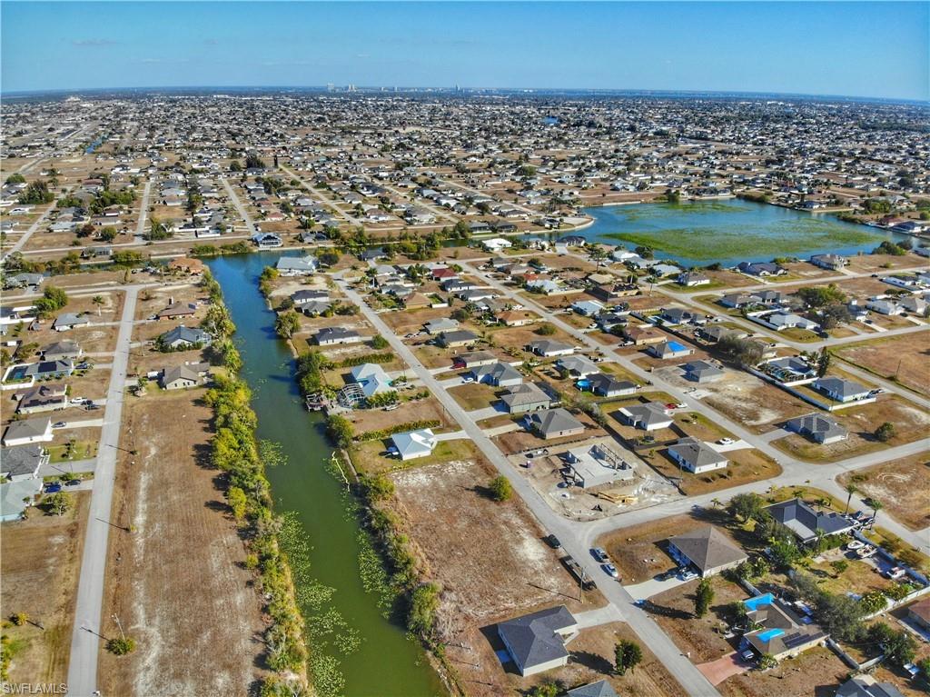 Aerial view of property's location featuring a nearby body of water and nearby suburban area