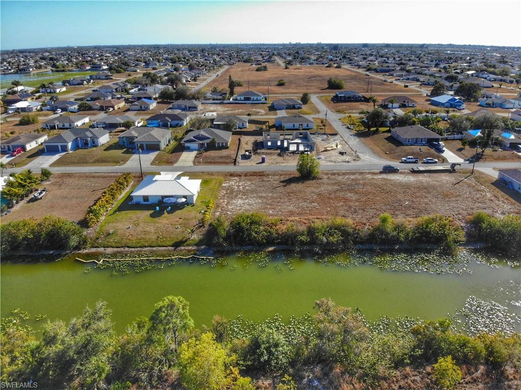 Aerial view of property and surrounding area with a large body of water and nearby suburban area