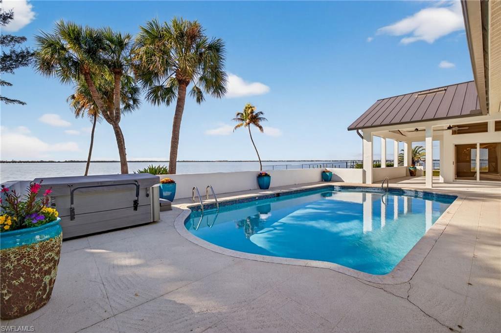 View of pool with a hot tub and patio surround