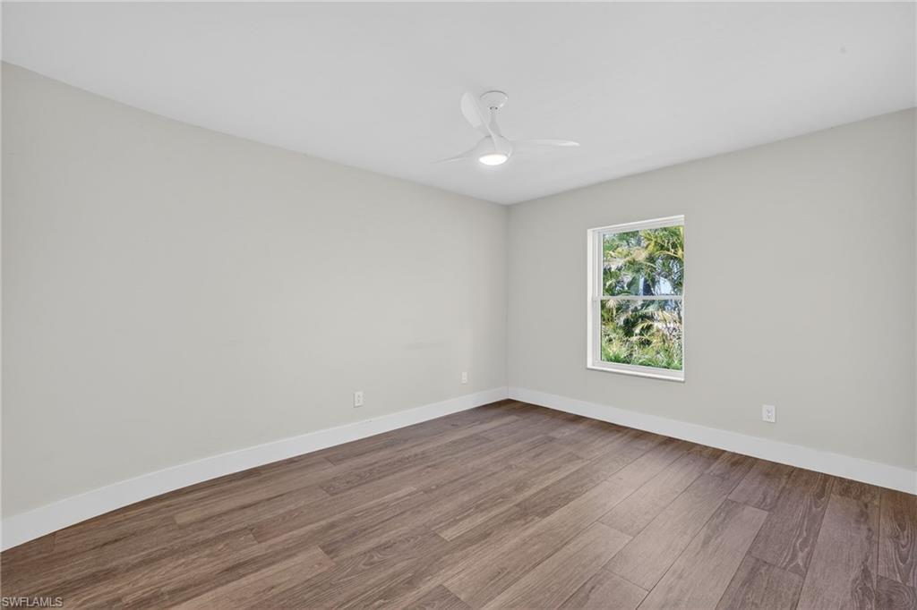Unfurnished room with wood finished floors and a ceiling fan