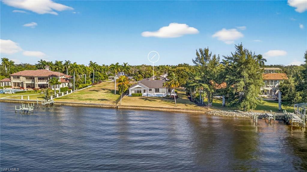 Water view with a dock and a tree filled landscape