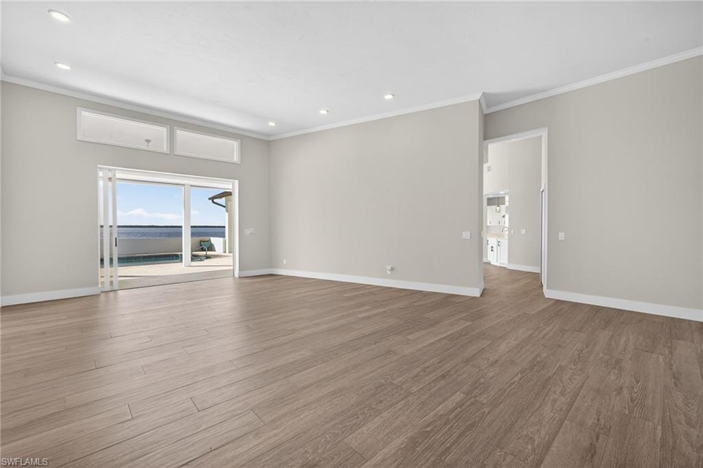 Unfurnished room with ornamental molding, light wood-type flooring, and recessed lighting