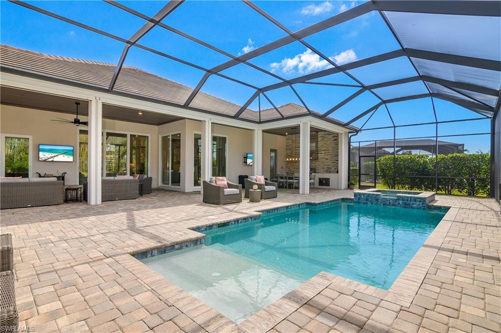 Combined pool / hot tub featuring outdoor seating, a sunroom, a lanai, and a patio area
