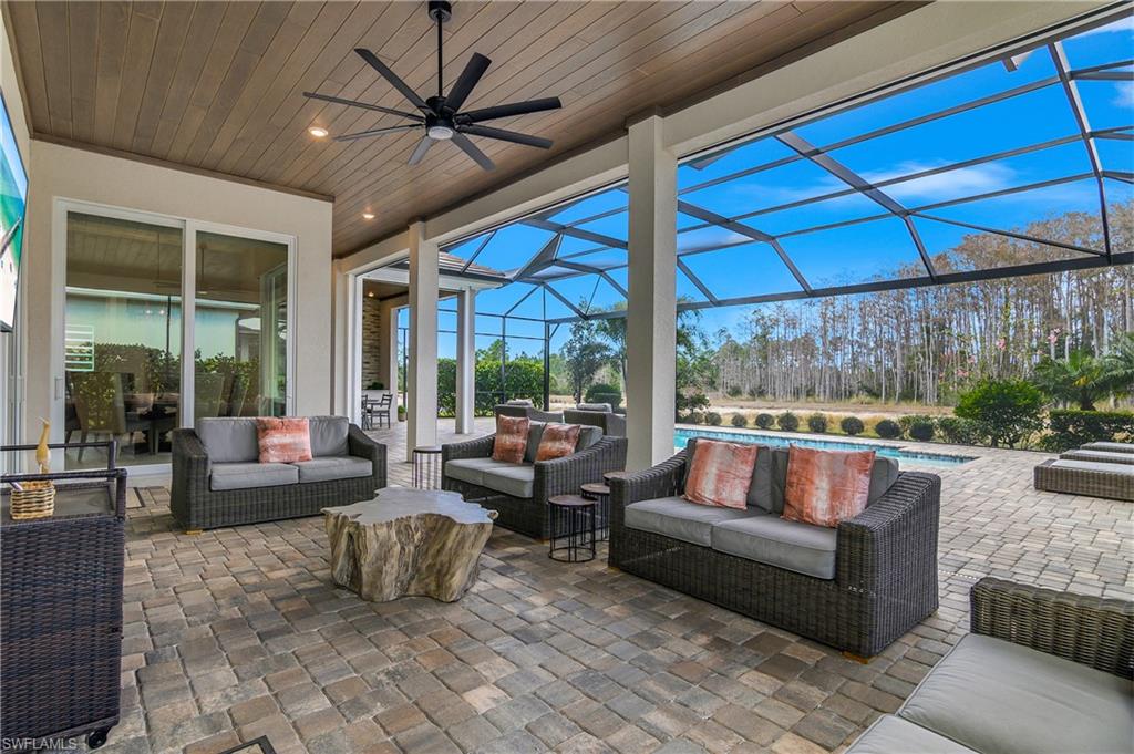 View of patio / terrace featuring outdoor seating, a sunroom, an outdoor pool, a lanai, and ceiling fan