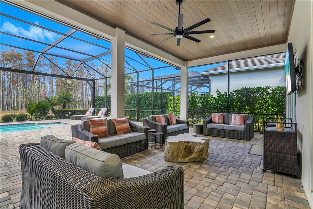 View of patio with outdoor lounge area, a sunroom, a lanai, ceiling fan, and an outdoor pool