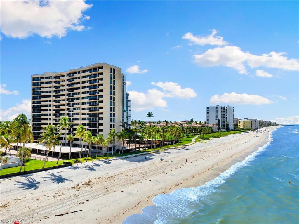 View of building exterior with a water view and a view of the beach
