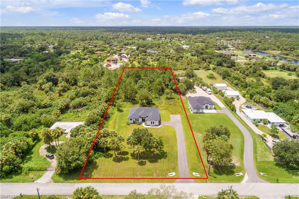 Aerial view of residential area with property boundaries highlighted and a nearby body of water