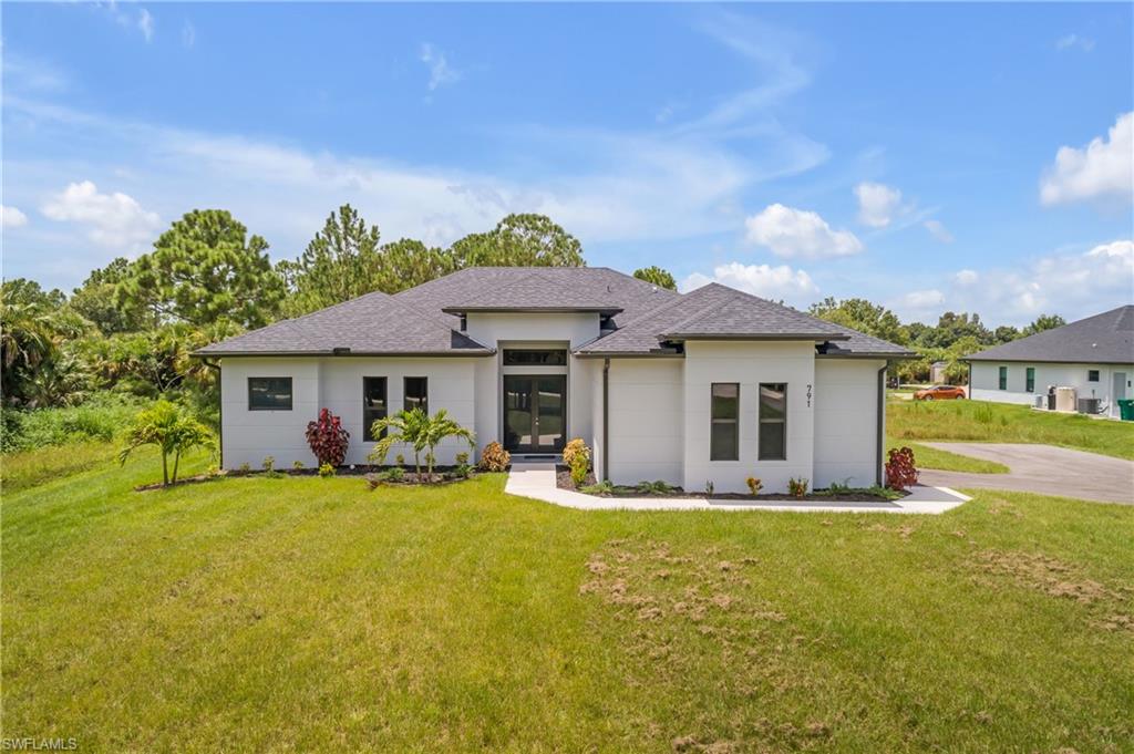 View of front of home featuring a front lawn and french doors