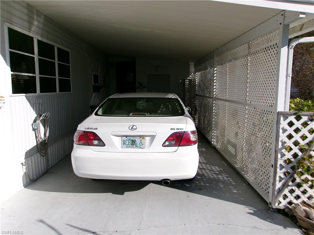 View of parking featuring an attached carport